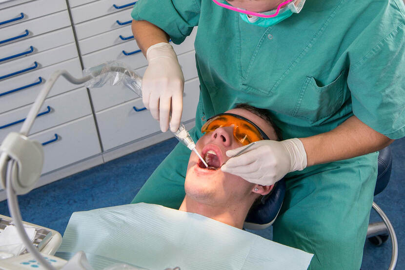 Een man wordt behandeld op de tandartsstoel.
