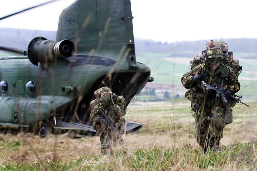 Luchtmobiele militairen zoeken dekking na uit een Chinook-helikopter te zijn gedropt.