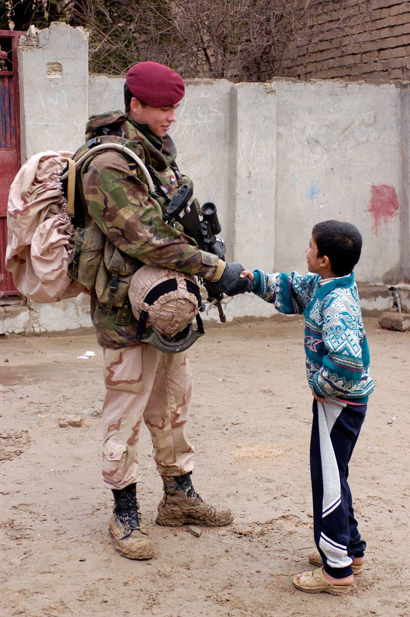 Een luchtmobieler geeft een Iraakse jongen een hand.