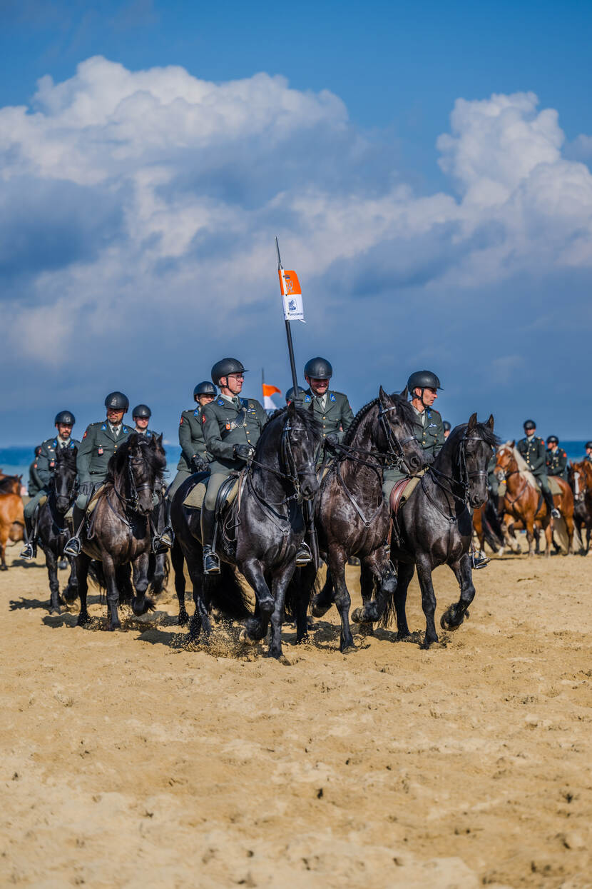 Militairen van de Cavalerie Ere Escorte te paard op het strand.