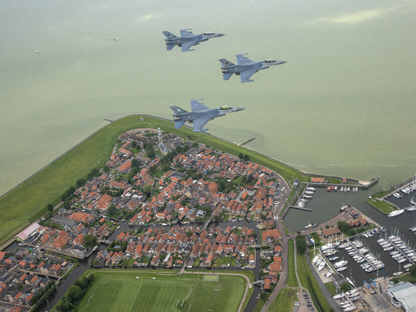 3 F-16's vliegen in formatie de Elfstedentocht, hier boven Hindeloopen.