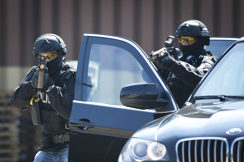 2 leden van het BSB-team met speciale beschermende kleding staan tijdens een oefening klaar om te schieten.